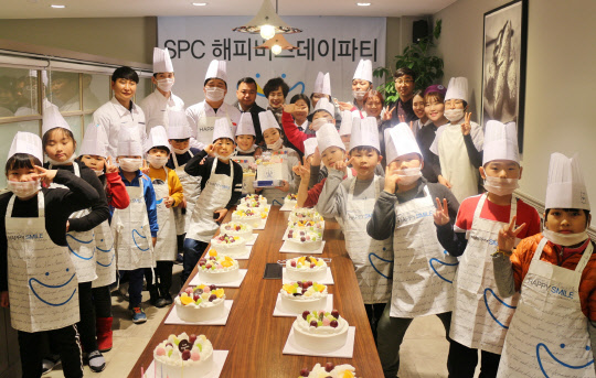 SPC해피봉사단은 지난 22일 파리바게뜨 부산용호점에서 'SPC 해피버스데이파티' 케이크 만들기 교실을 진행했다. 이날 행사에서 SPC해피봉사단원들과 부산 상리지역아동센터 어린이들이 기념촬영을 하고 있다.   SPC그룹 제공